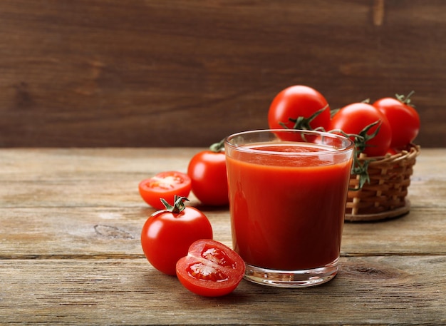 Vaso de jugo de tomate fresco sobre un fondo de madera