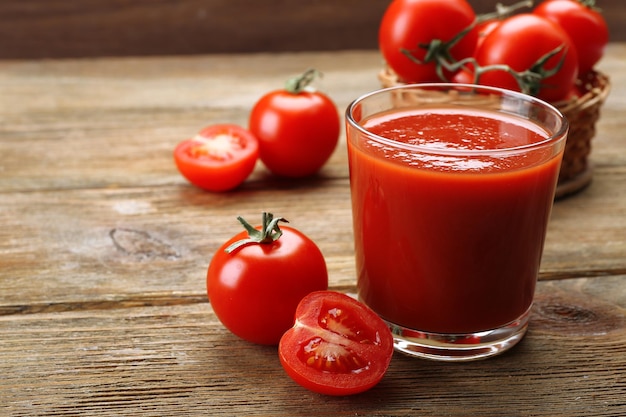 Vaso de jugo de tomate fresco sobre un fondo de madera