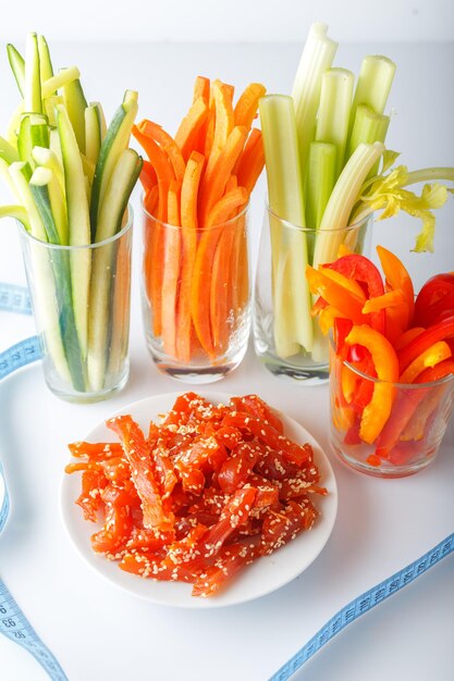 vaso con jugo de verduras cortadas en tiras comida dietética bocadillos en un plato trozos secos de carpacci