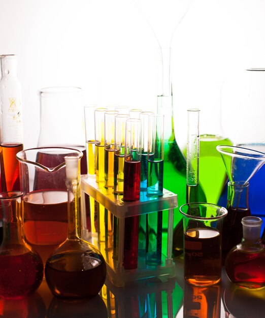 Vaso de laboratorio con líquidos de colores del arco iris, bodegón de química