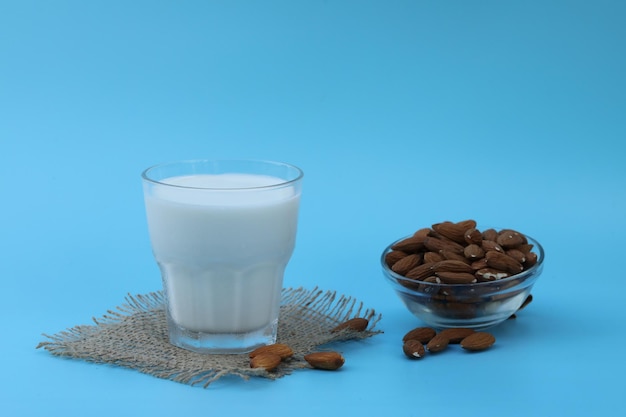 vaso de leche de almendras en el fondo azul con espacio de copia