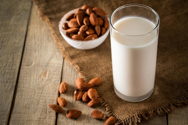 Vaso de leche de almendras sin lactosa sobre un fondo de madera.