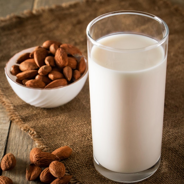 Vaso de leche de almendras sin lactosa sobre un fondo de madera