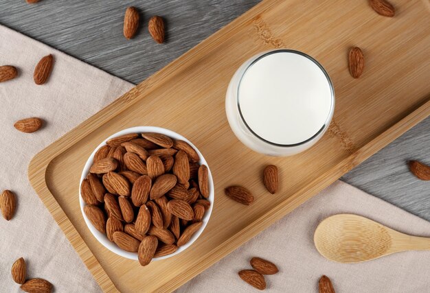 Un vaso de leche de almendras sobre la mesa almendras esparcidas por todas partes Leche de almendras alternativa