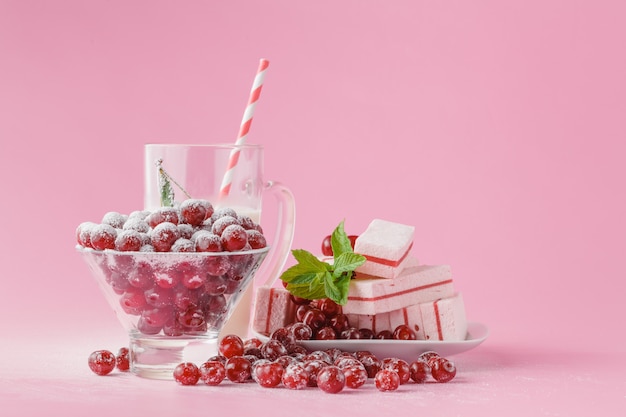 Vaso de leche y azúcar en polvo espolvoreado con cerezas y menta