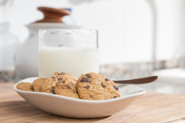 Vaso de leche y bandeja con galletas con chispas de chocolate