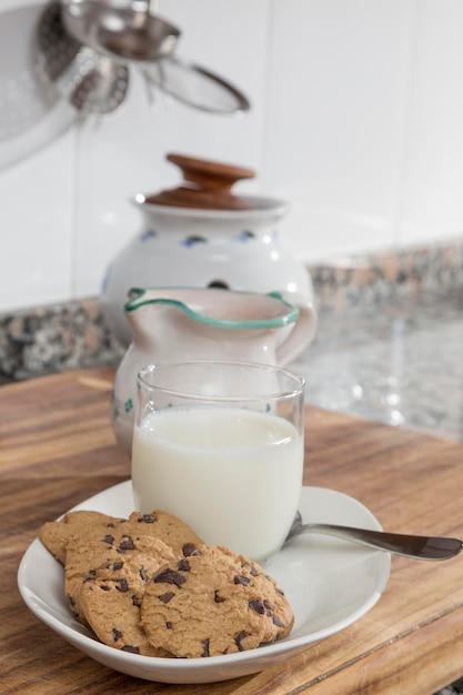 Vaso de leche y bandeja con galletas con chispas de chocolate