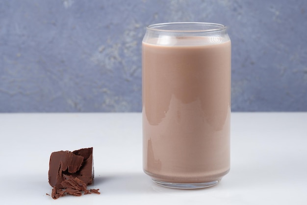 Vaso de leche con chocolate en la mesa, espacio para texto