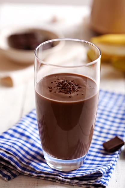 Vaso de leche con chocolate en primer plano de la mesa