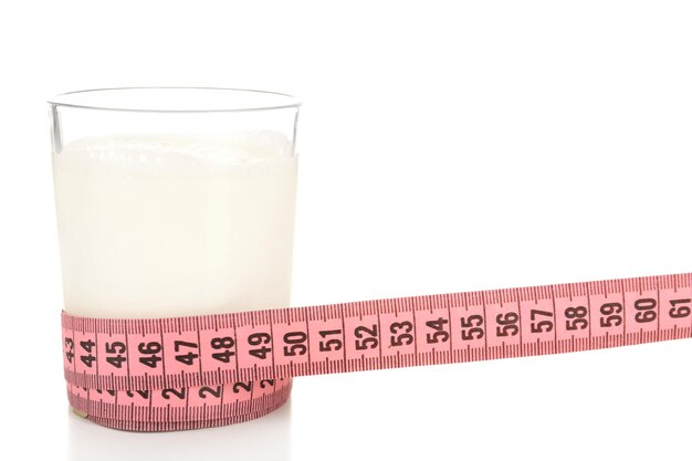 Vaso de leche con cinta métrica aislada en blanco