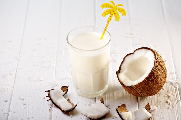 Vaso de leche de coco en la mesa de madera blanca. Enfoque selectivo