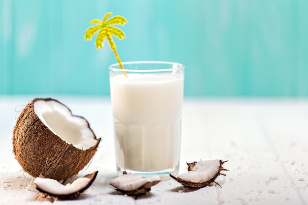 Vaso de leche de coco en la mesa de madera blanca