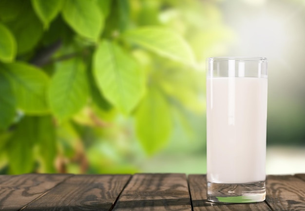 Foto un vaso de leche fresca en un escritorio de madera