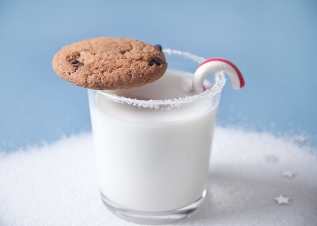 Vaso de leche, galleta, bastón de caramelo en azul