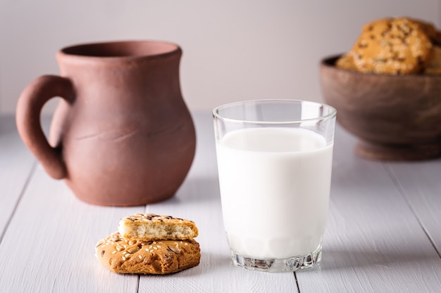 Vaso de leche y galletas en la mesa de madera