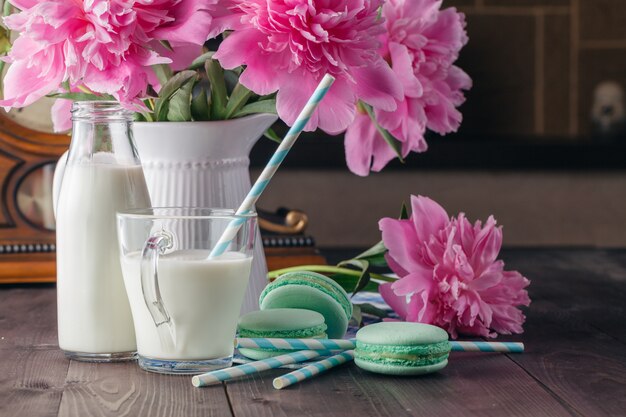 Vaso de leche con macarrones en mesa de madera