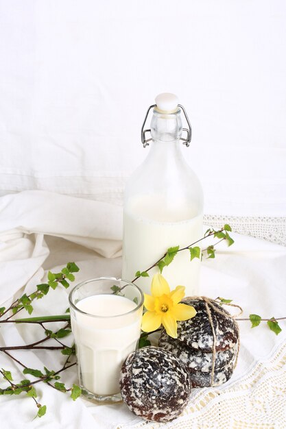 Vaso de leche y pasteles dulces con jengibre y vainilla cocina casera rústica fondo blanco.