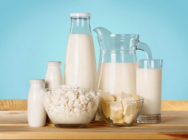 Vaso de leche y productos lácteos en el fondo