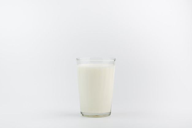 Foto un vaso de leche sobre un fondo blanco.