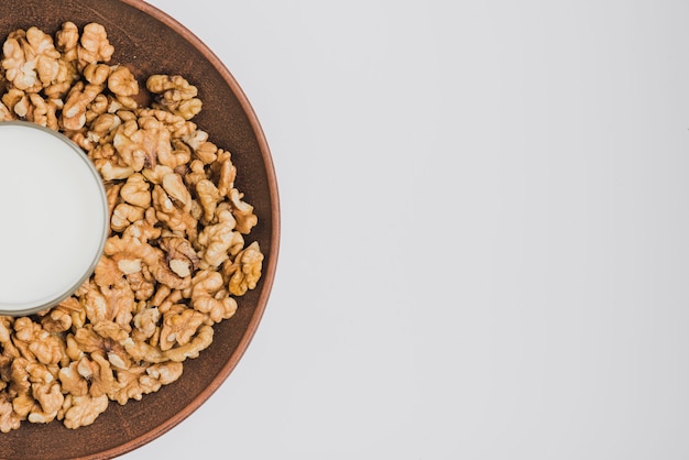 Foto vaso de leche en un tazón con nueces