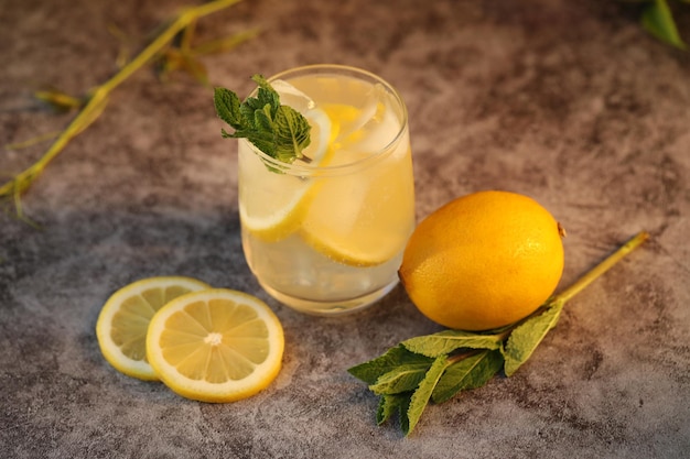 Vaso de limonada fría con limón y menta