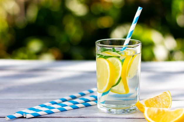 Foto un vaso de limonada con rodajas de limón y lima día soleado de verano