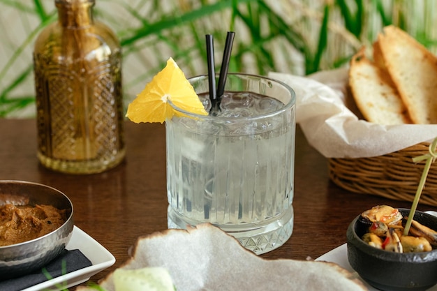 Un vaso de limonada se sienta en una mesa con una rodaja de limón.