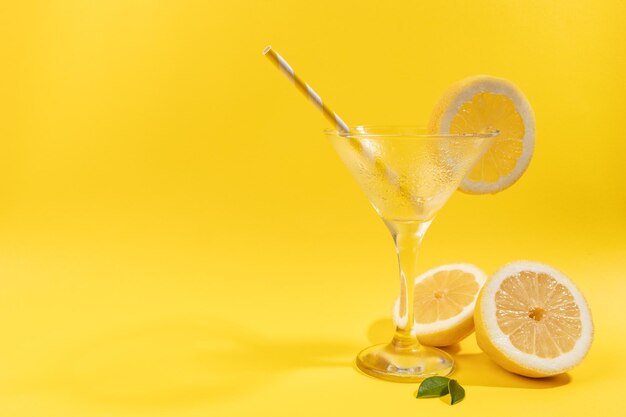 Vaso de limonada vacío con limón sobre fondo amarillo