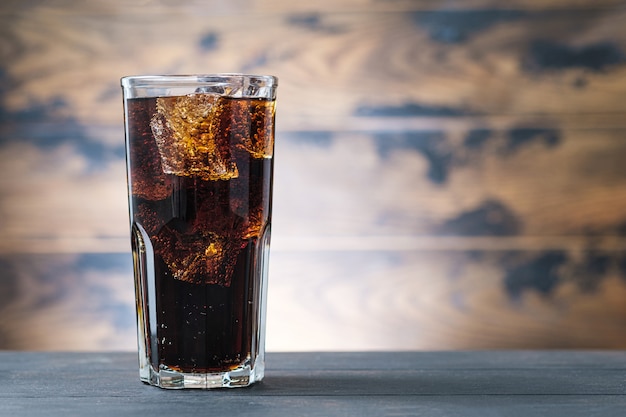 Vaso lleno bebida cola con cubitos de hielo. Soda con burbujas