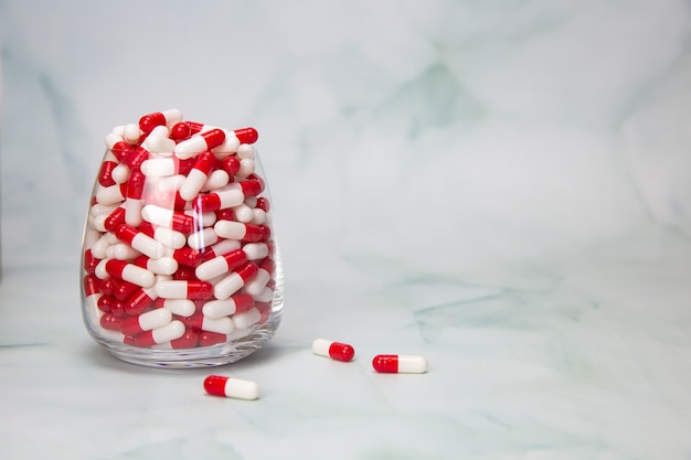 Vaso lleno con cápsulas, píldoras para medicamentos, medicamentos o vitaminas, una variedad de tabletas de medicamentos farmacéuticos.