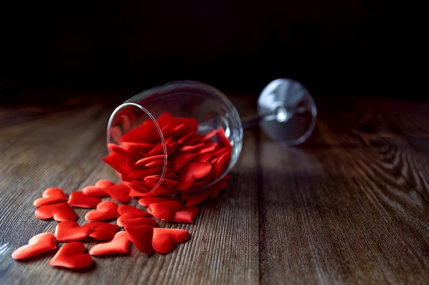 Un vaso lleno de corazones rojos sobre un fondo oscuro Día de San Valentín