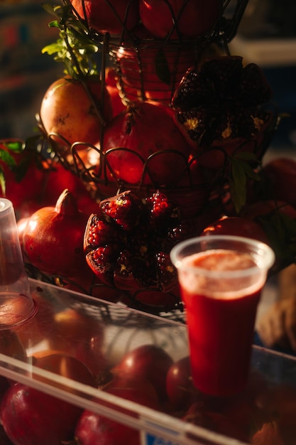 Foto un vaso lleno de jugo de granada con granadas en la parte de atrás