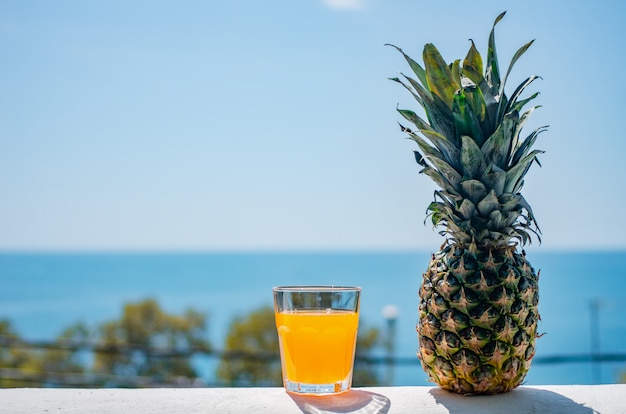 Foto un vaso lleno de zumo contra el telón de fondo del mar.