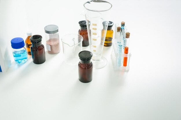 Vaso de medida, tubos de ensayo y frascos de vidrio. Concepto de salud y biotecnología