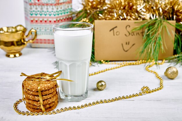 Vaso de Navidad con leche y galletas en la mesa