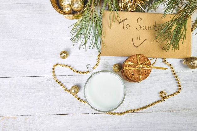 Vaso de Navidad con leche y galletas para Santa en la mesa