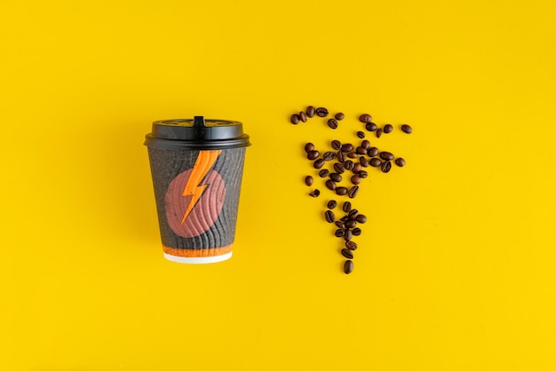 Un vaso de papel para bebida caliente con granos de café sobre fondos de color