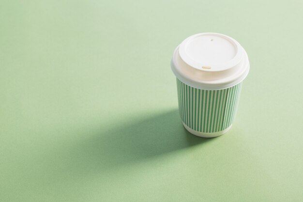 Vaso de papel desechable con café en verde