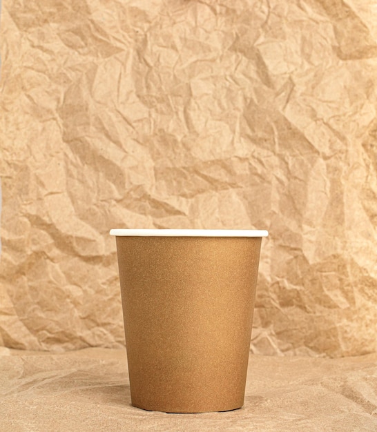 Vaso de papel desechable en el fondo de papel kraft arrugado Concepto de uso de vajilla ecológica desechable