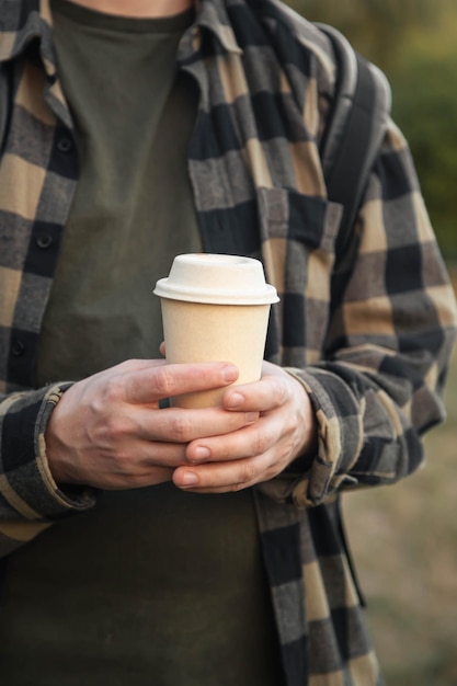 Vaso de papel con tapa de papel en manos masculinas fuera de primer plano concepto de desperdicio cero vajilla ecológica