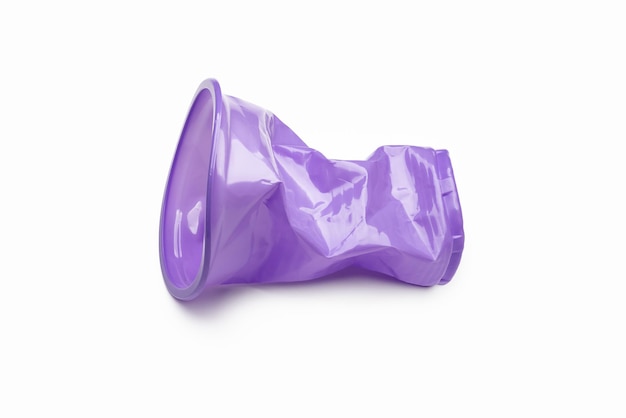 Foto vaso de plástico púrpura arrugado aislado en blanco. el concepto de ecología y reciclaje.
