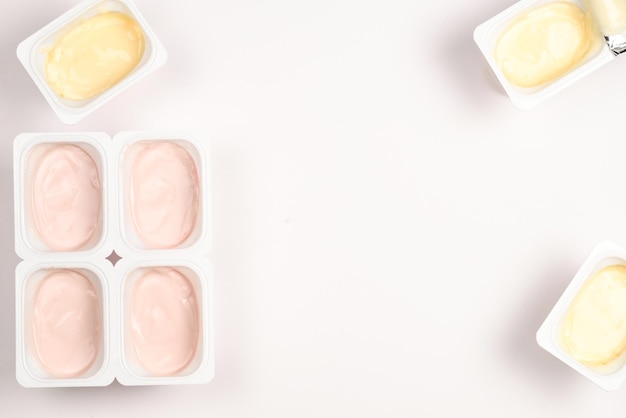 Vaso de plástico con sabroso yogur aislado en blanco Vista superior Espacio para texto o diseño