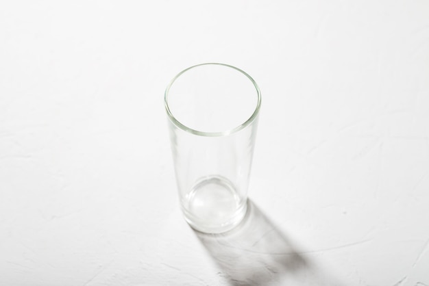 Vaso de precipitados de vidrio vacío sobre un fondo blanco Claro sombra luz dura