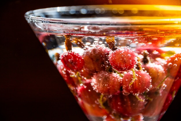 Vaso de refrescante bebida fría de verano con bayas y cubitos de hielo