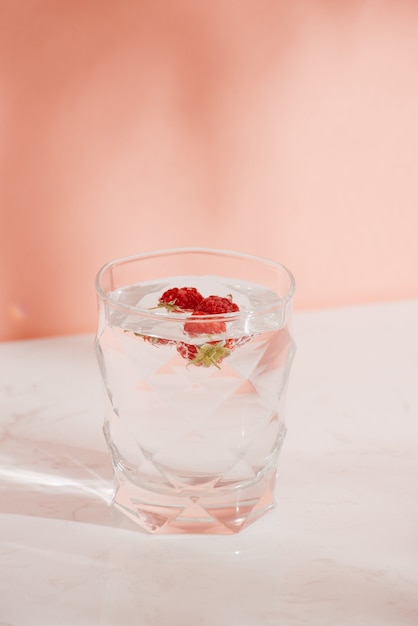 Un vaso de refresco con frambuesas