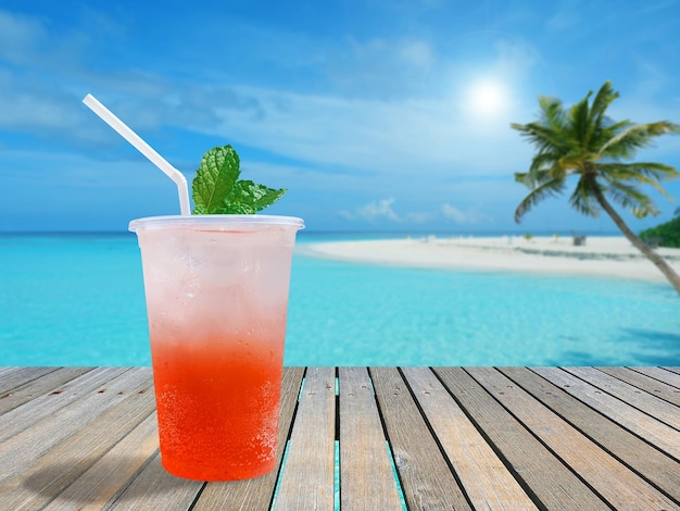 Un vaso de refresco de fresa helado en una terraza de madera junto al mar en un día soleado con espacio para copiar