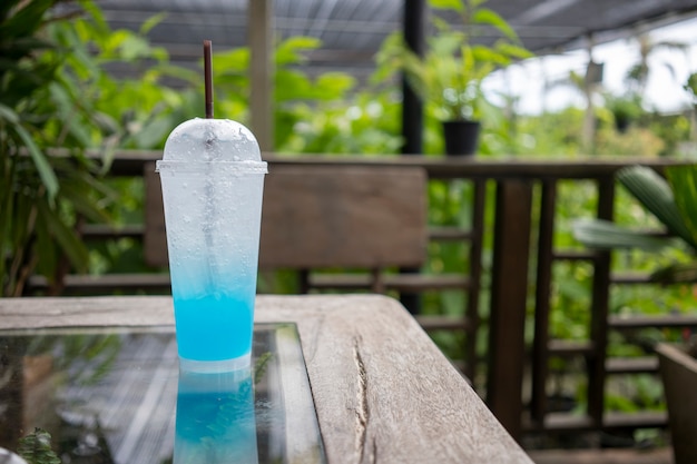 Un vaso de refresco frío se coloca sobre una mesa de madera.