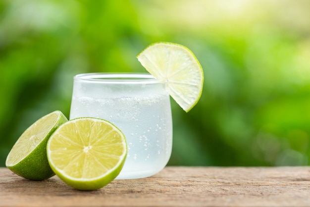 Foto vaso de refresco de limón helado en la mesa de madera con espacio de desenfoque verde para texto o diseño