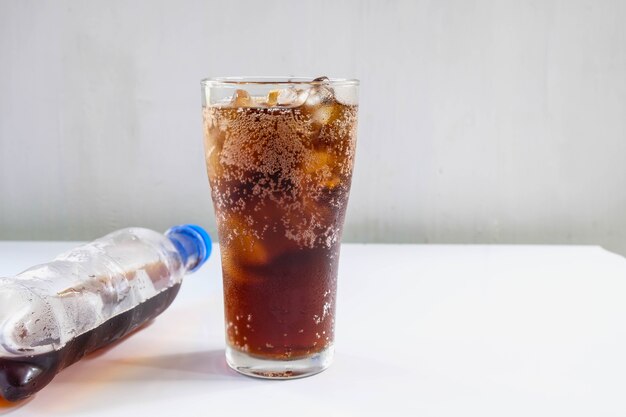 Vaso de refrescos y refrescos negros sobre la mesa