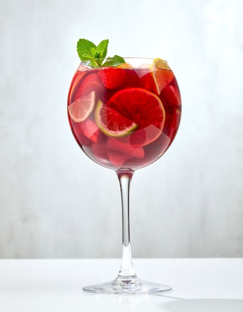 Vaso de sangría roja en mesa de restaurante gris